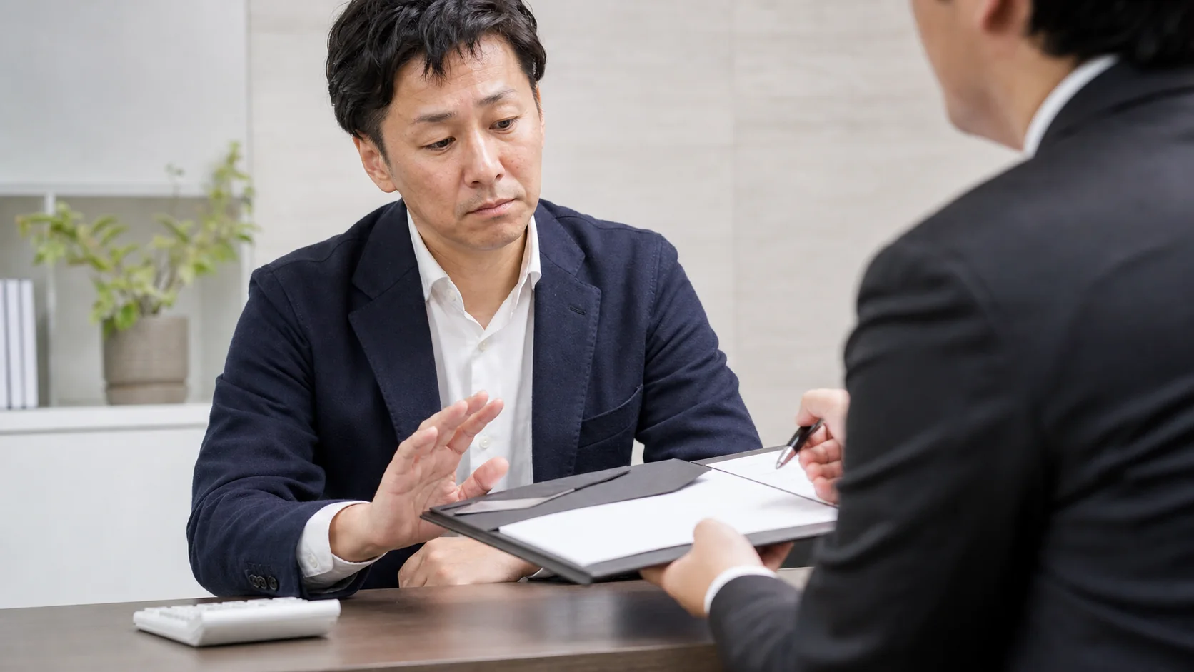 不審なファクタリング契約書を慎重に確認する中小企業経営者