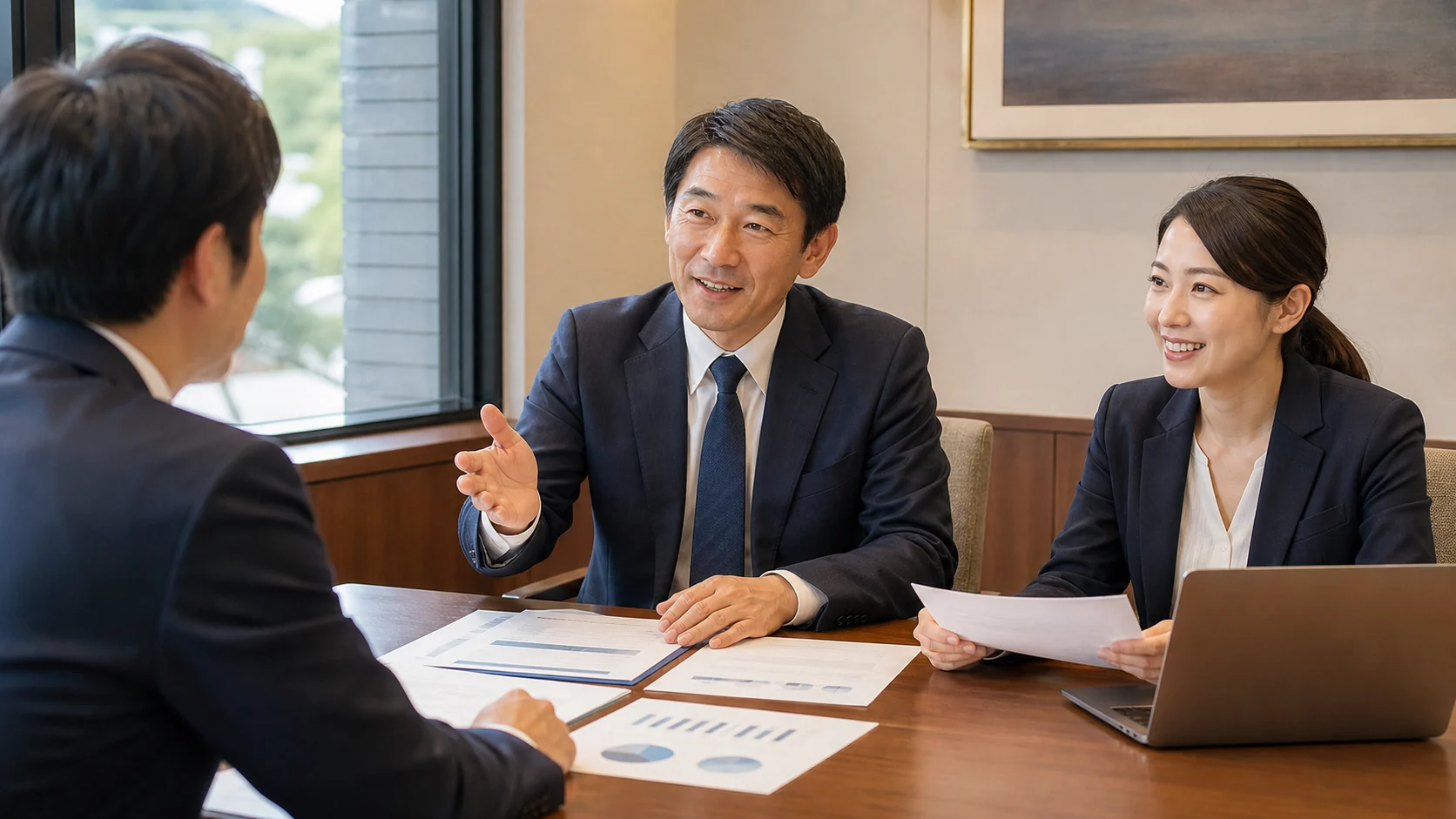 経営者と財務担当者が最新月次資料と重要事象を金融機関へ説明する場面