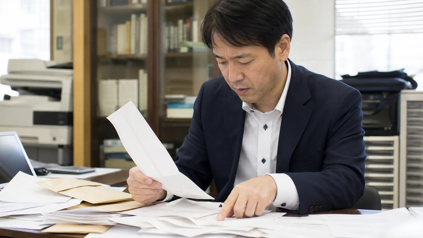 サービス会社の経営者と経理担当が銀行入出金と仮受金・預り金明細を照合する場面