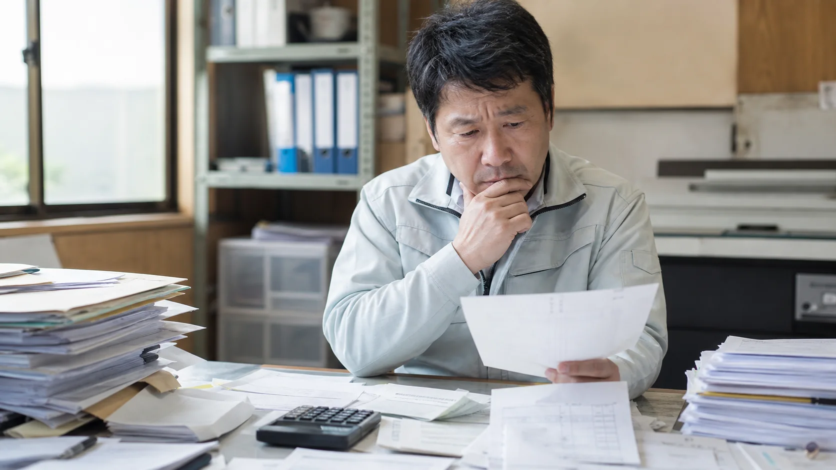 仕入請求書と設備見積書を分けて確認する中小企業経営者
