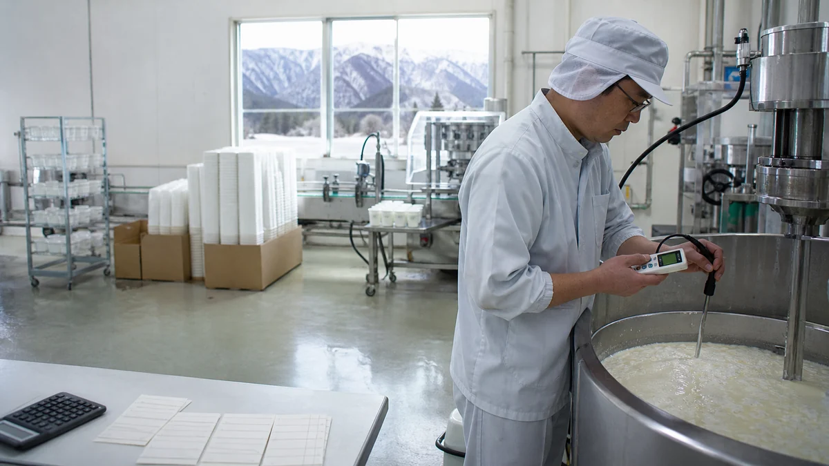 南牧村の乳製品工場でヨーグルトの凝固差を再確認し、停止した充填ラインと購入済み容器を見直す技術者